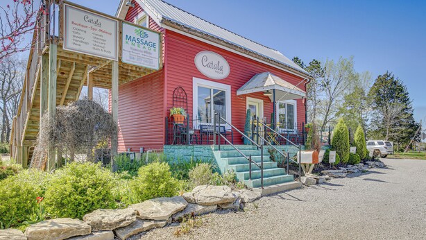 A red building with a sign for 'Catala House' and a 'Massage House' sign. - New Melle Apartment Near Missouri Wine Country (Wentzville)