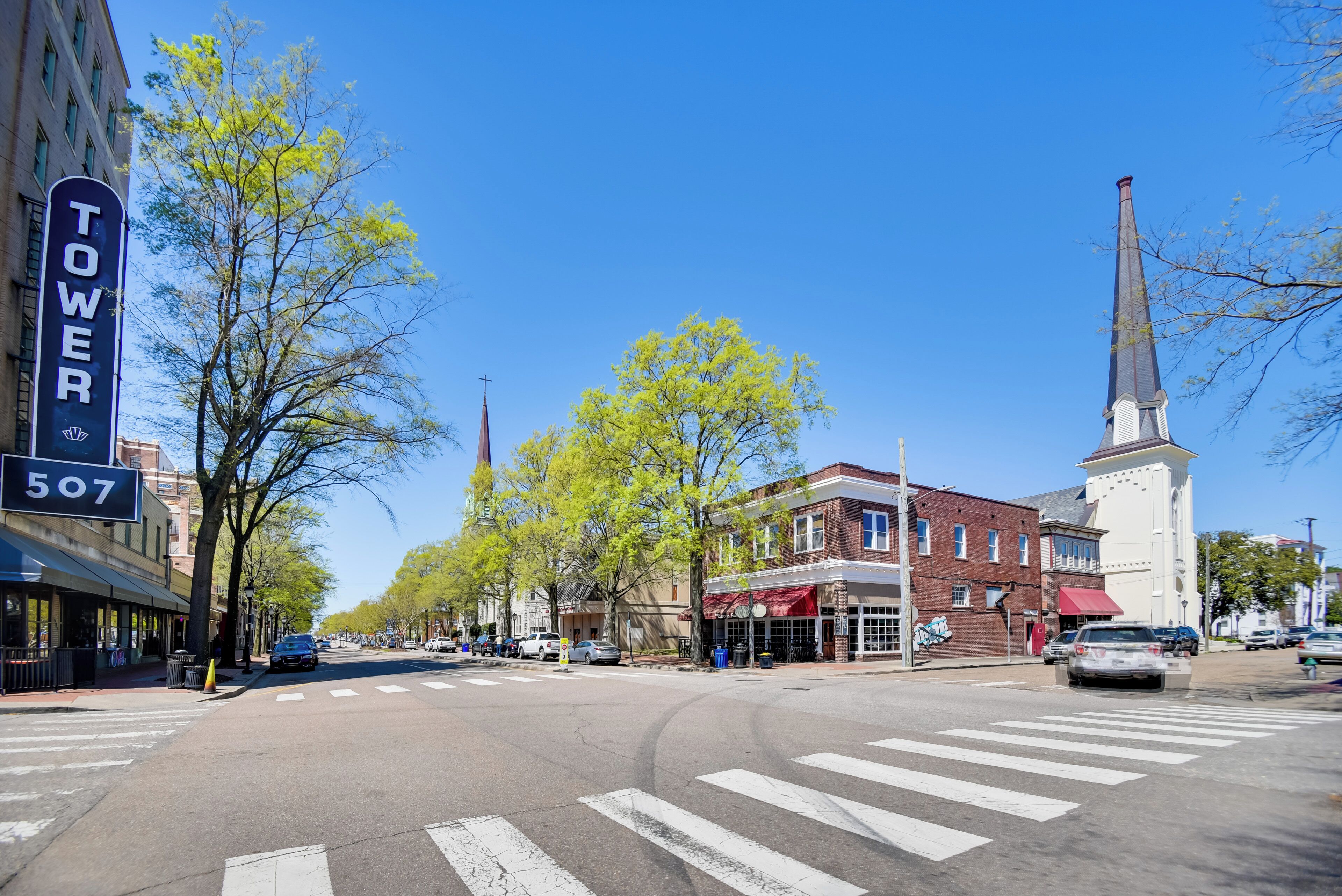 Une vue de rue avec un bâtiment portant l’inscription « TOUR 507 », le clocher d’une église et un passage piéton.
