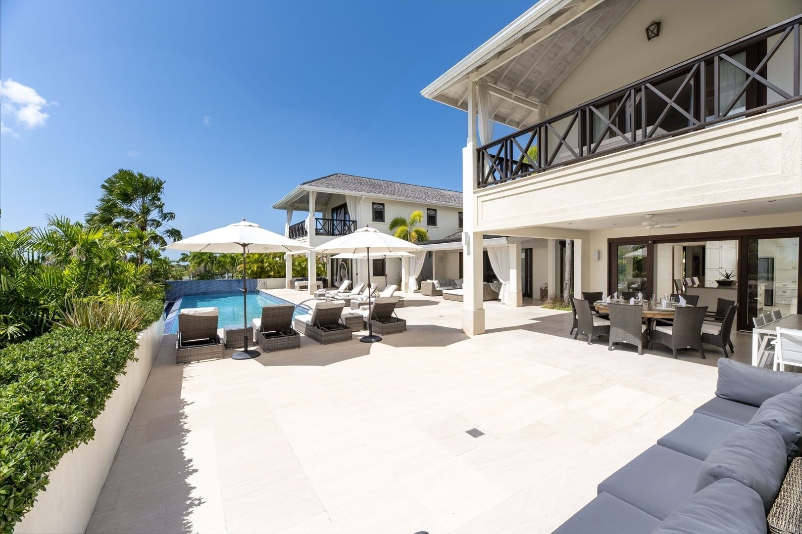 Una casa moderna amb piscina, mobiliari exterior i una àrea de pati espaiosa.