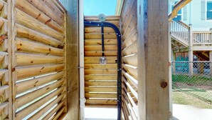 A wooden gate with a metal lock and a hose running through it. - Salty Sea House: 3  BR, 2  BA House in Crystal Beach , Sleeps 12 (Bolivar Peninsula)