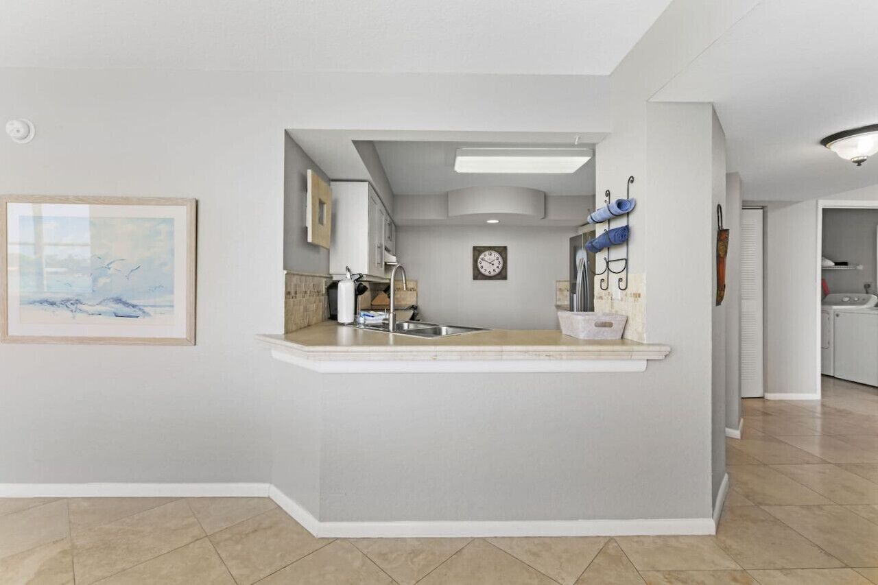 Una cocina moderna con una isla integrada, un lavamanos y un reloj en la pared.