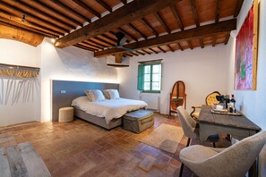 Relax in this charming bedroom with a large bed, wooden bench, and small table.