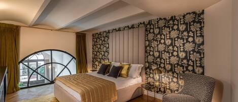 A bedroom with a bed, a chair, a window, and a patterned wall.