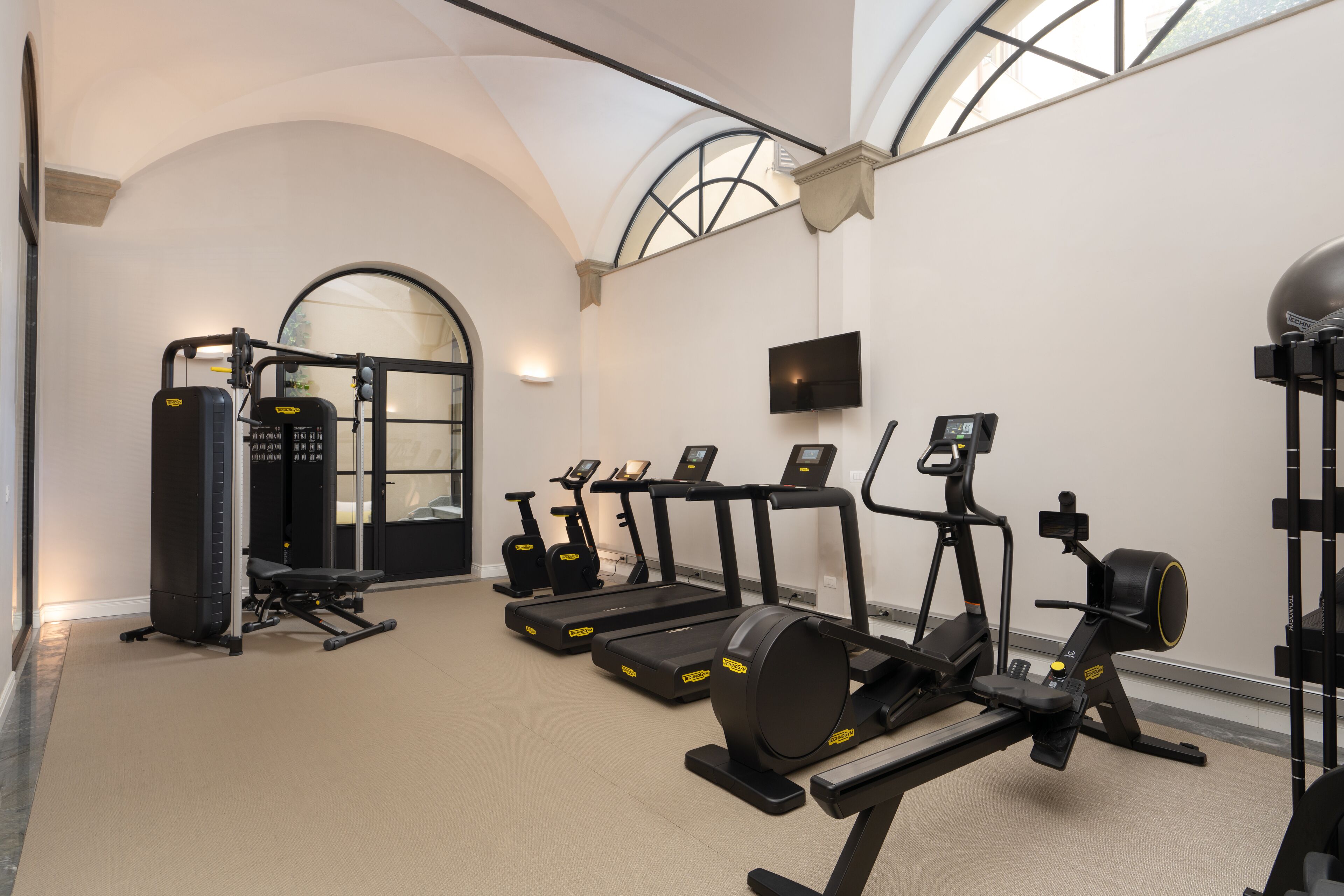 A gym with treadmills, elliptical machines, and weight equipment.