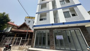 Un edificio de varios pisos con fachada moderna, amplios ventanales y un letrero que indica espacio para oficinas o negocios.