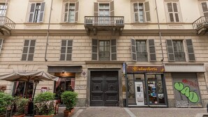 A building with a black door, a sign for "Al Tagliere," and a "Cafeteria" sign. - La Corte by Wonderful Italy (Torino)
