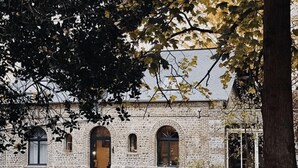 Un edificio in pietra con finestre ad arco e una facciata in mattoni.