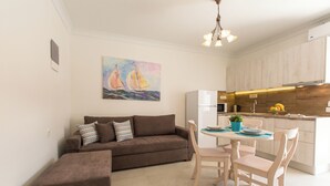 Een moderne keuken met houten kastjes, een witte koelkast, en een eethoek met een tafel en stoelen.