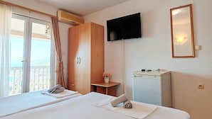 Een hotelkamer met een groot bed, een flatscreen televisie aan de muur en een klein bureau met een stoel.