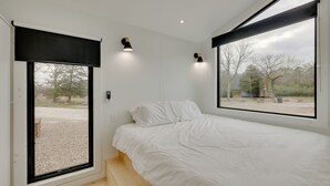 Une chambre à coucher avec un lit, une fenêtre et une porte.