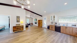 A spacious kitchen with wooden cabinets, a dishwasher, and a large window.