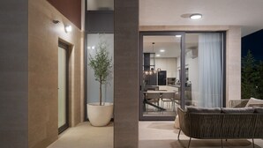 A modern outdoor living area with a dining set, a potted plant, and a sliding glass door leading to a kitchen. - New Villa 55-Vrsi heated pool jacuzzi sauna bbq sea view (Vrsi)