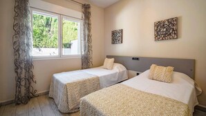 A hotel room with two beds, a window with curtains, and two wall art pieces. - Villa Pomera Dos by Villa Plus (Beniarbeig)