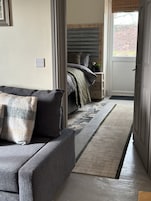 Un dormitorio moderno con una cama, una mesita de noche y vistas al exterior.
