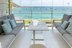 Una habitación moderna con un amplio ventanal con vistas a una playa y al mar.