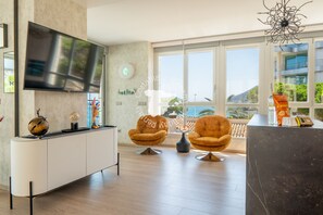 A modern living room with a large TV, two armchairs, a marble counter, and large windows with a view. - CostaBlancaDreams - Bauprés in Calpe (Calpe)