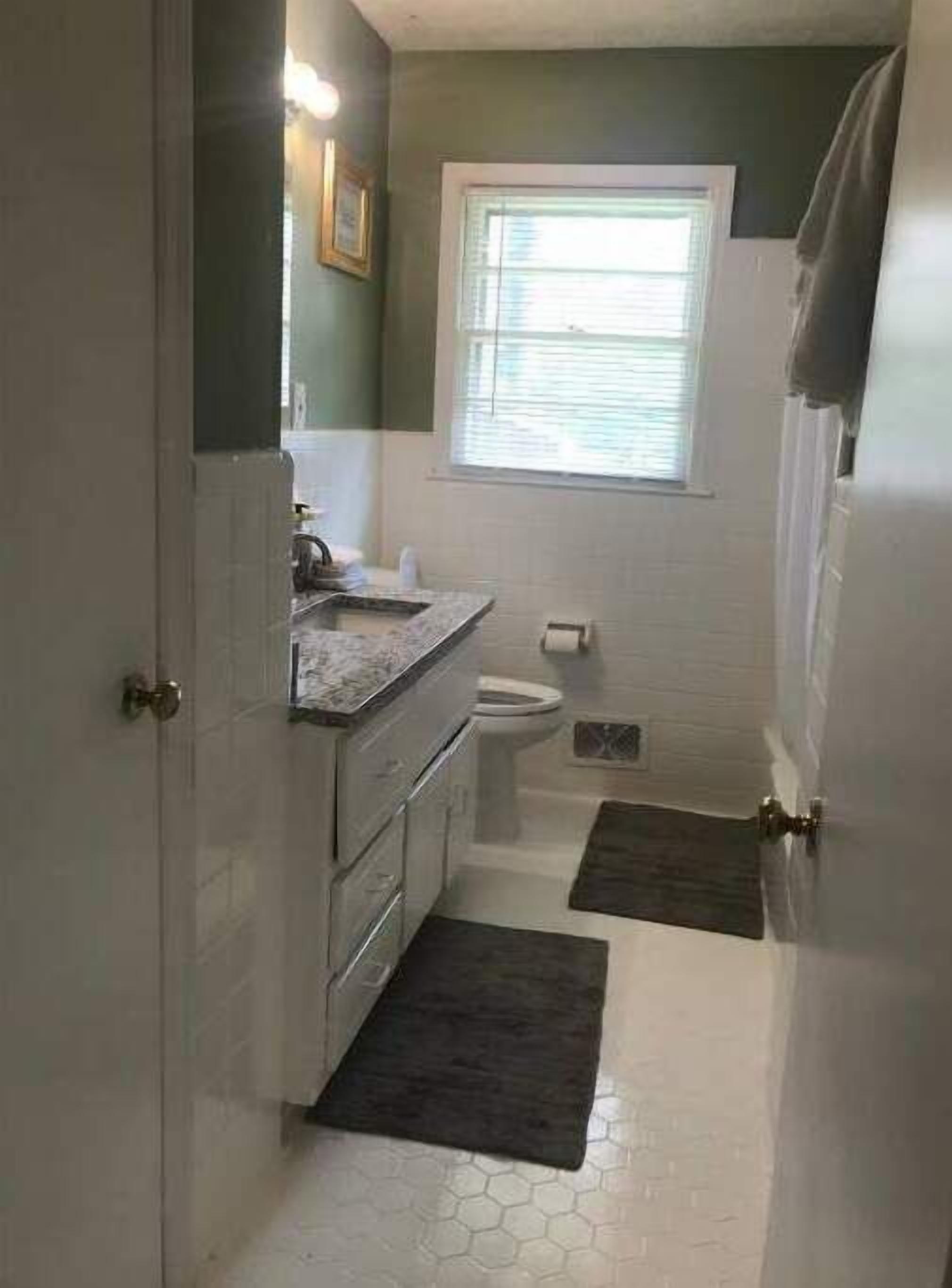 A compact bathroom with a toilet, sink, and a small window.