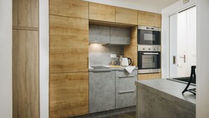 Une cuisine moderne avec des meubles en bois, un plan de travail gris et des appareils électroménagers en acier inoxydable.