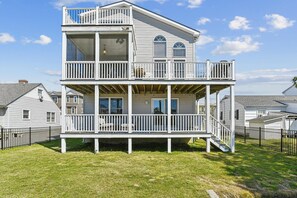 A two-story house with a balcony and a covered porch. - Bayside Retreat in Bethany Beach: Short Walk to Beach, Sleeps 13, Water Views! (Bethany Beach)