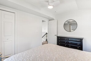 A bedroom with a bed, dresser, and a mirror on the wall. - Bayside Retreat in Bethany Beach: Short Walk to Beach, Sleeps 13, Water Views! (Bethany Beach)