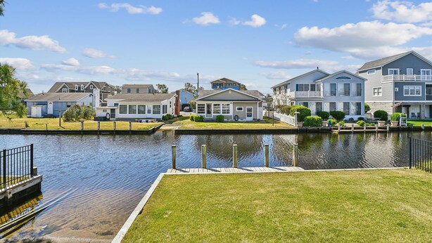 A waterfront residential area with houses, a dock, and a canal.