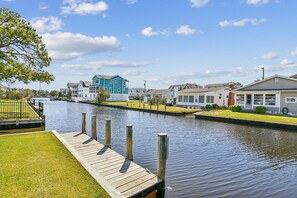 A canal with houses on one side and a wooden dock on the other. - Bayside Retreat in Bethany Beach: Short Walk to Beach, Sleeps 13, Water Views! (Bethany Beach)