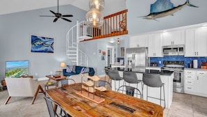 A modern kitchen with white cabinets, a stainless steel refrigerator, and a black countertop. - Pool, Key Colony Beach, Dock, Across from the Golf Course (Key Colony Beach)