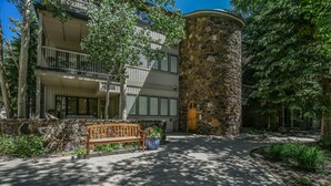 A building with a stone tower, a wooden bench, and a paved walkway. - Chateau DuMont Oversized 2 Bed 2 Ba CDMR (Keystone)