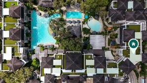 Oversigtsbillede af et resort med flere swimmingpools, en central pool og et ikon for et gæstehus, der angiver en placering.