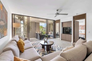 A modern living room with a sofa, a coffee table, and a TV.