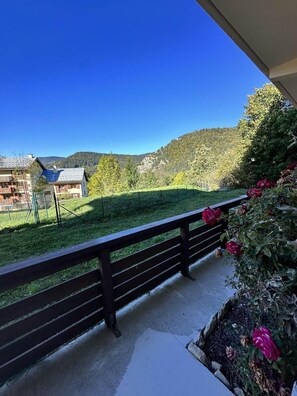 A balcony with a view of a green field and buildings in the distance. - Ground floor, balcony, tv, 50m², Villard de Lans (Villard-de-Lans)