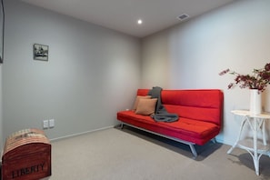 A room with a red sofa, a small white table with a vase, and a red box labeled 'LIBERTY'.