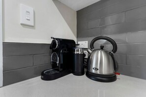 A kitchen counter with a coffee maker and a kettle. - 1-bed wow factor in Kohimarama (Auckland)
