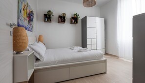 Une chambre à coucher moderne, comprenant un lit, des tables de chevet, une armoire et des étagères murales ornées de plantes.