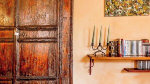 A wooden door, a shelf with books and a Buddha statue, and a painting on the wall. - Lovely 2-bed Apartment in Roma (Rome)