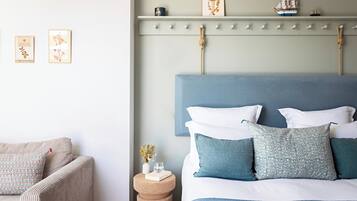 A bedroom with a bed, a chair, a bedside table, and wall decorations.