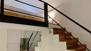 Eine Treppe mit Holzbodenstufen und einem schwarzen Metallgeländer.