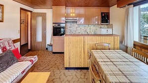 A compact room with a kitchenette, a sofa, a bed, and a window with a view. - Wifi, 2nd floor, terrace, balcony, parking, 50m², Les Gets (Les Gets)
