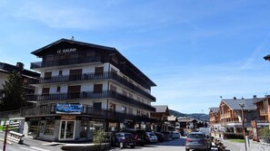A multi-story hotel with balconies, a restaurant, and a parking area. - Wifi, 200m from ski lifts, 4th floor, balcony, 35m², Les Gets (Les Gets)