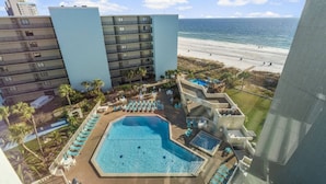 Un hotel con piscina, vistas a la playa y varios pisos.