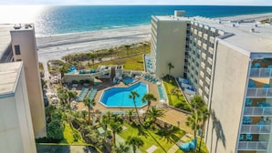 Un hotel con piscina, vistas a la playa y varios balcones.