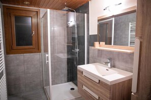 Enjoy a refreshing shower in the bathroom with a glass-enclosed shower, vanity, and mirror.