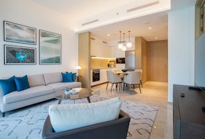 Relax in this stylish living room with a comfortable sofa, dining area, and fully equipped kitchen.