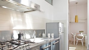 Une cuisine moderne équipée d’appareils électroménagers en acier inoxydable, d’une cuisinière à gaz et d’un réfrigérateur.