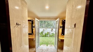 A hallway with a glass door leading to a garden. - Pat-Mase Villas Jimbaran (badung)