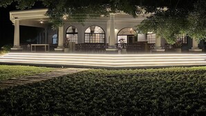 A building with a symmetrical facade, arched windows, and a central entrance with steps leading up to it. - Le Palais d'Akwa (Abidjan)