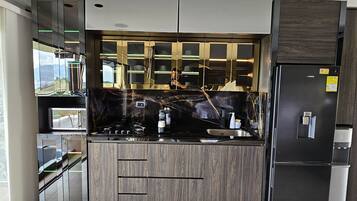 Fridge, microwave, coffee/tea maker, cookware/dishes/utensils