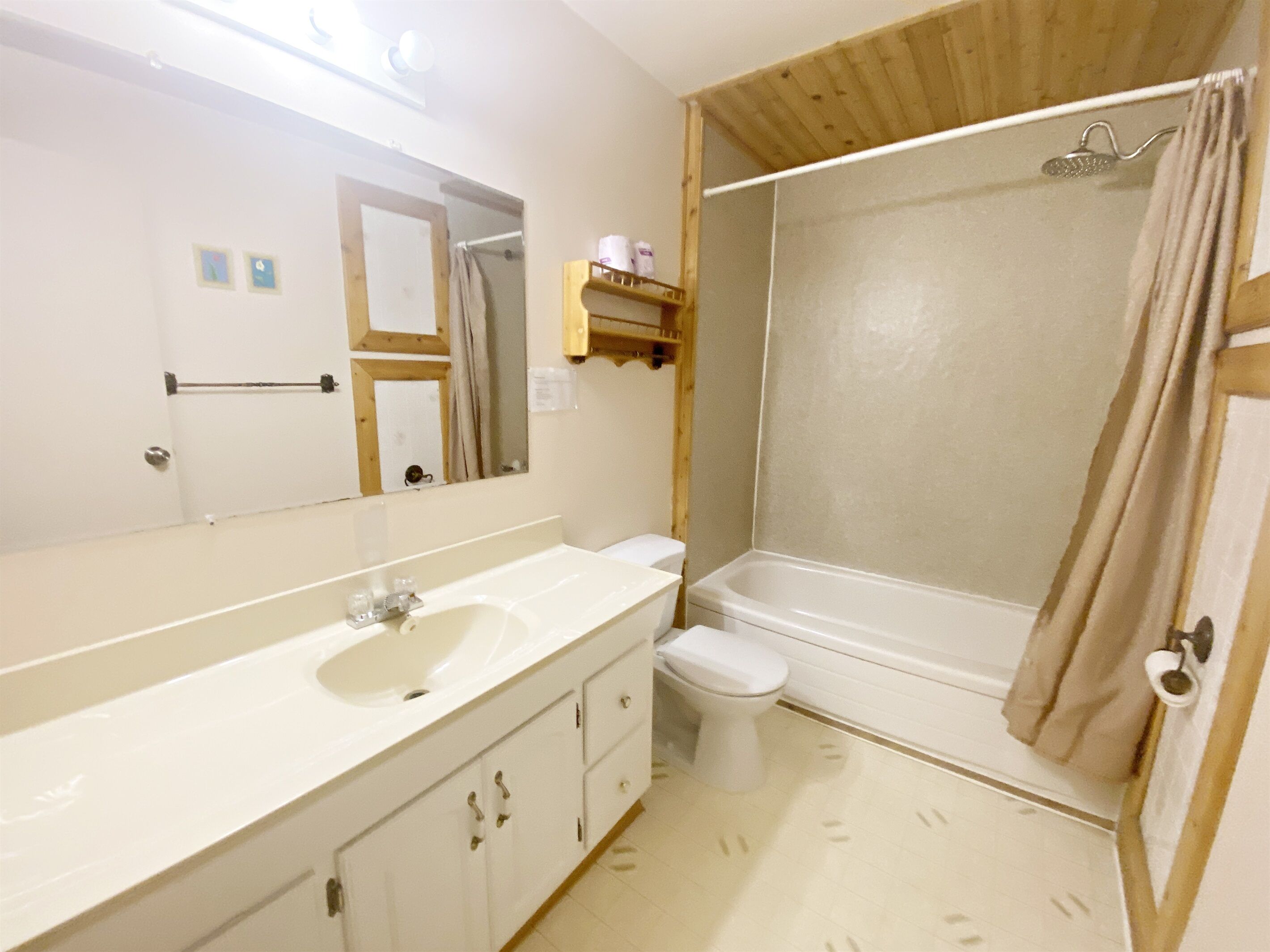 A bathroom with a sink, toilet, and shower.