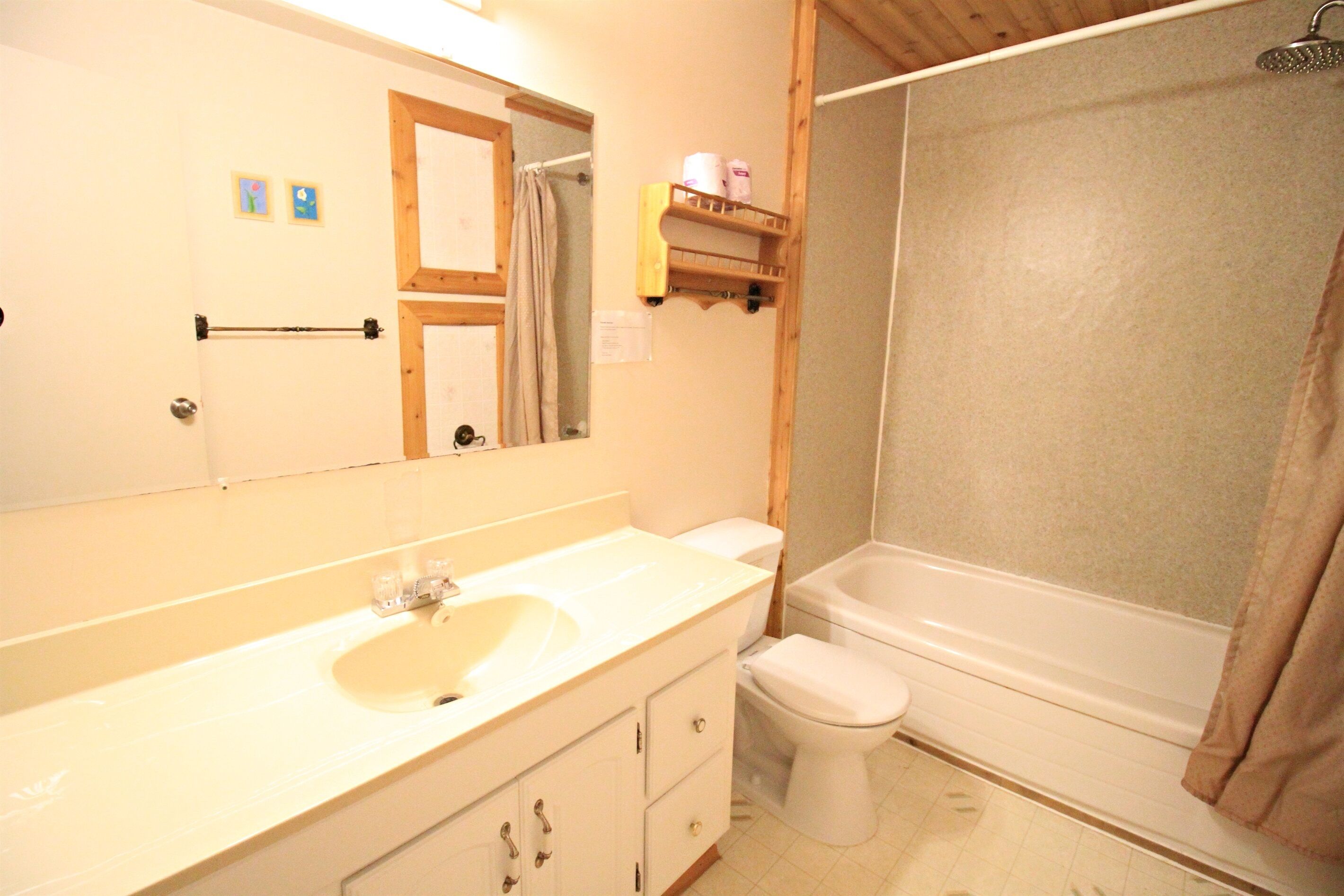 A bathroom with a sink, toilet, and shower.