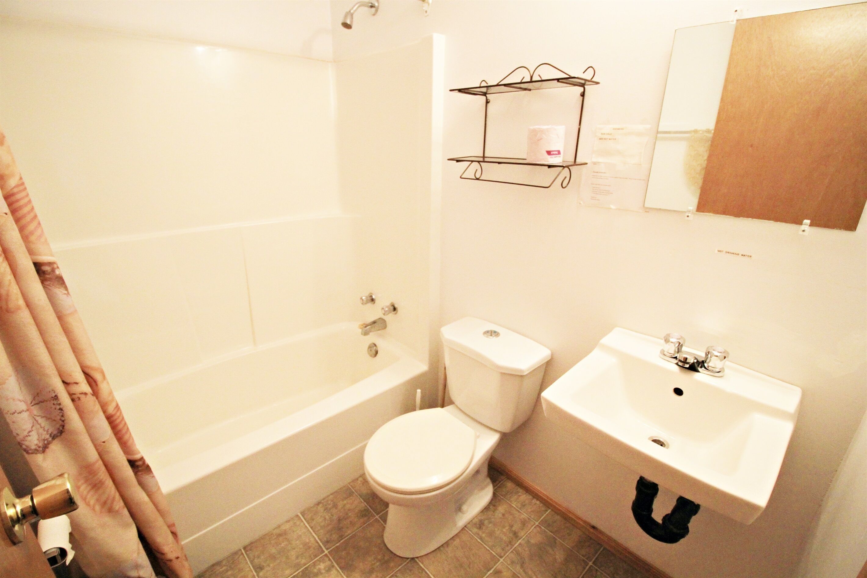 A bathroom with a bathtub, toilet, and sink.